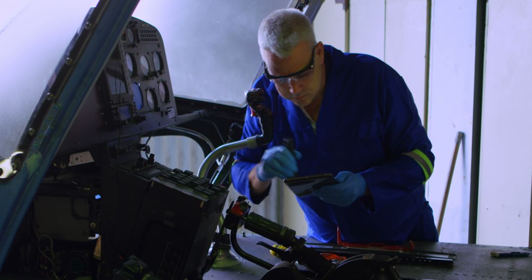 Engineer Inspecting Helicopter Cockpit with Tablet - Free Images, Stock Photos and Pictures on Pikwizard.com