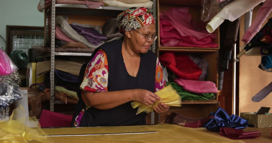 Senior Woman Working with Colorful Fabric in Textile Shop - Free Images, Stock Photos and Pictures on Pikwizard.com