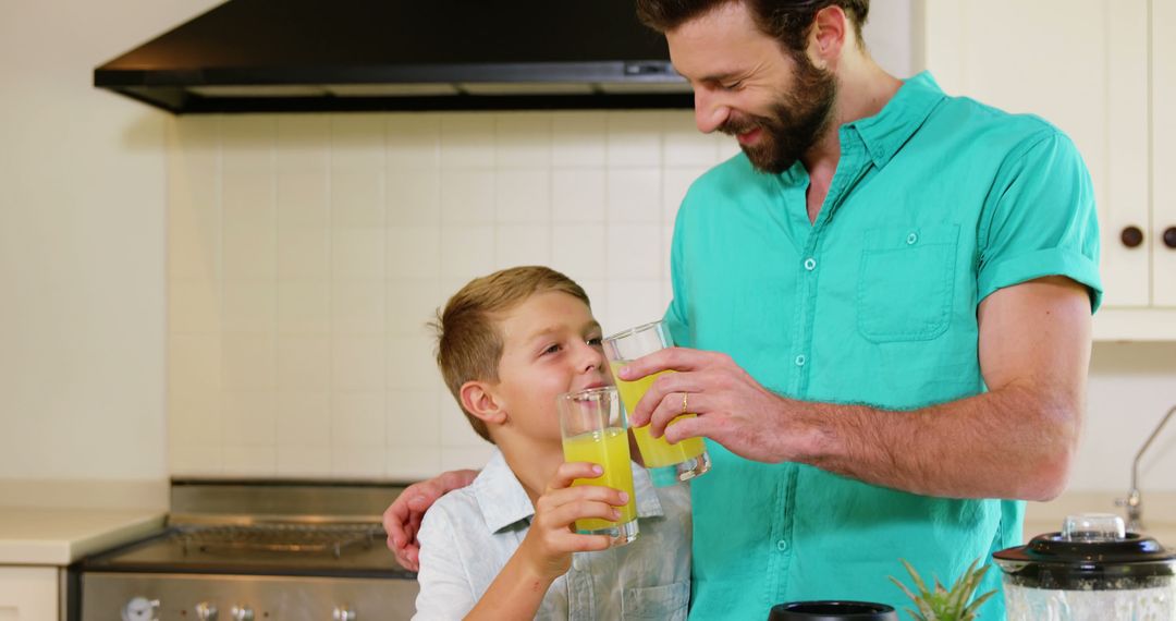 Father and Son Enjoying Fresh Juice in Kitchen - Free Images, Stock Photos and Pictures on Pikwizard.com