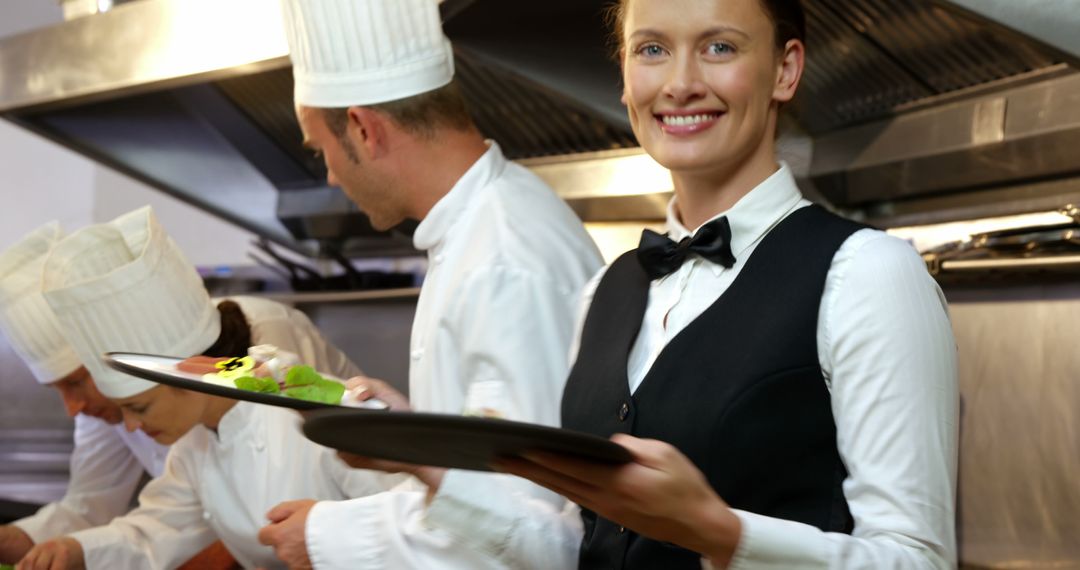 Smiling Waitress Serving in Restaurant Kitchen - Free Images, Stock Photos and Pictures on Pikwizard.com