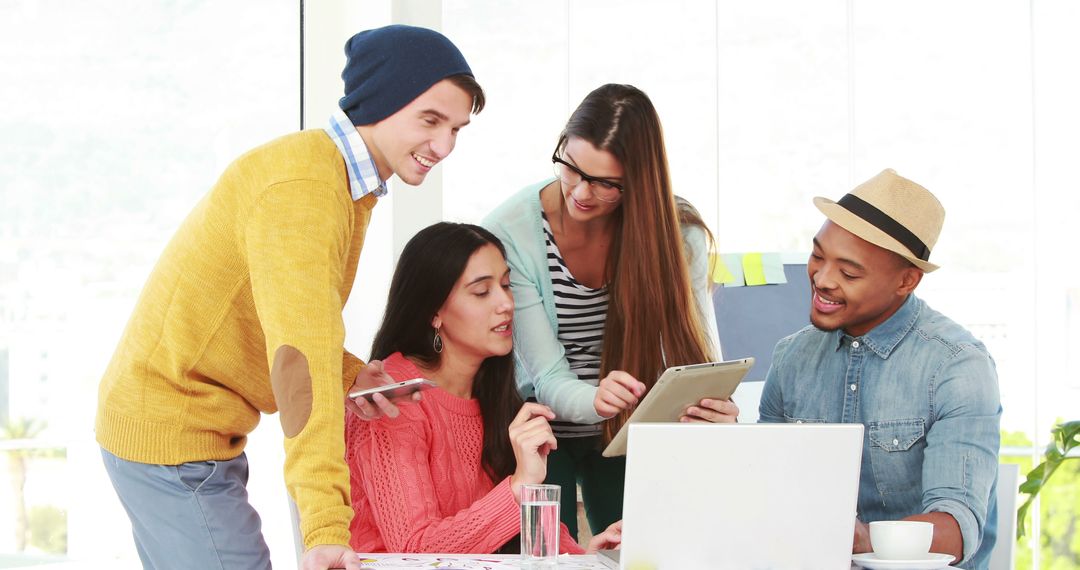 Diverse Creative Team Collaborating Over Digital Tablet in Modern Workspace