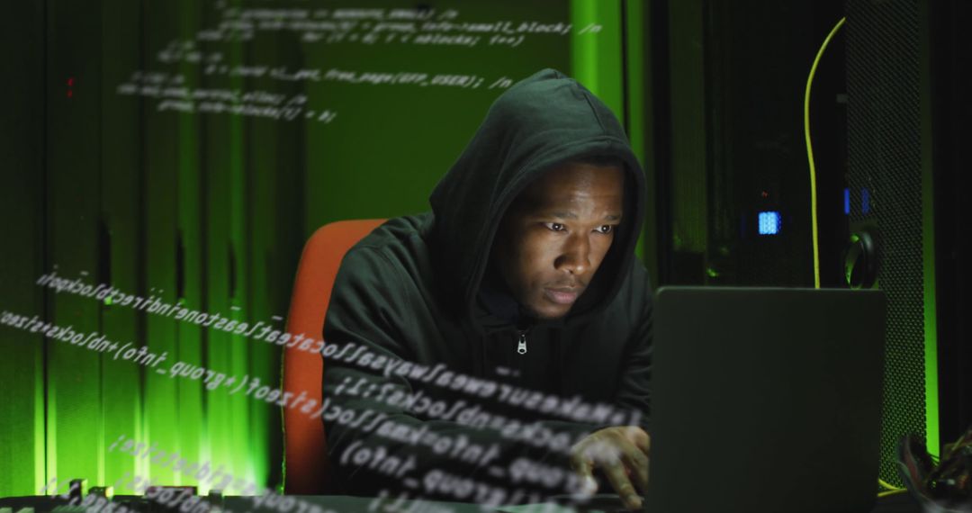 Cybersecurity Expert Using Laptop in Green-Lit Server Room