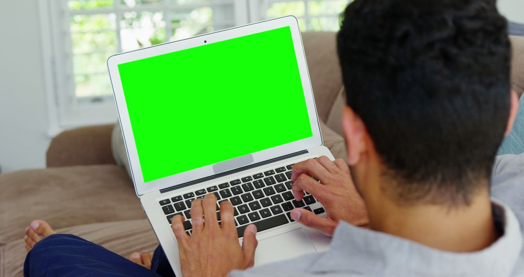 Person Sitting on Sofa Using Laptop with Green Screen - Free Images, Stock Photos and Pictures on Pikwizard.com