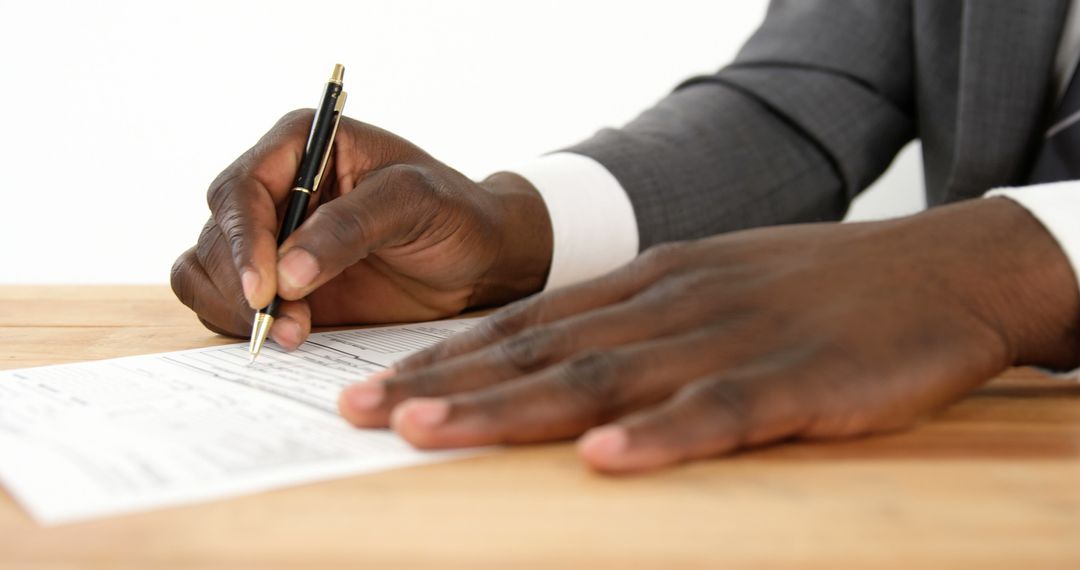 Close-up Of African American Businessman Signing Document - Free Images, Stock Photos and Pictures on Pikwizard.com