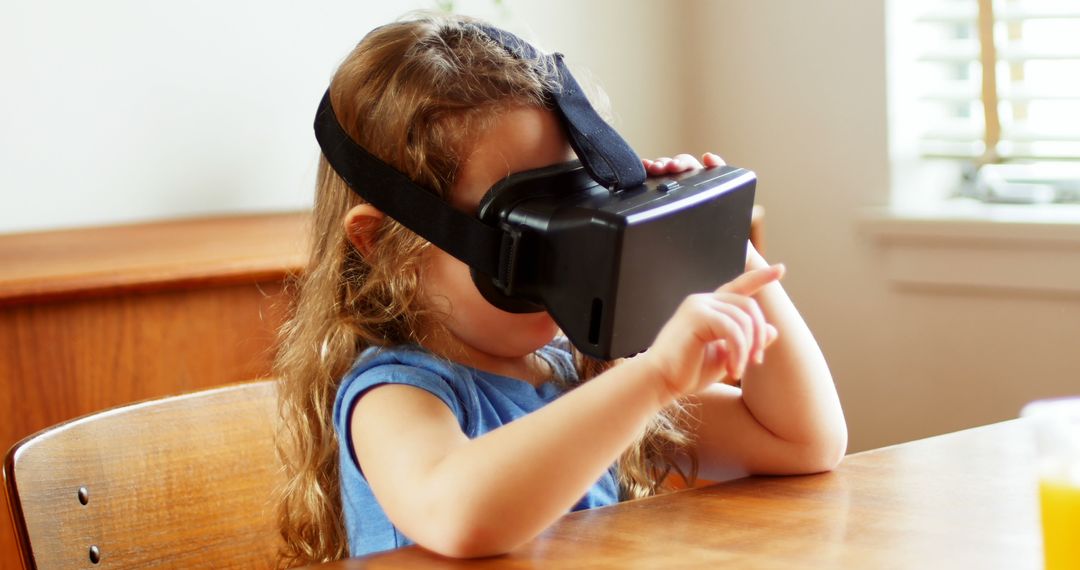 Young Girl Interacting with Virtual Reality Simulator at Wooden Table - Free Images, Stock Photos and Pictures on Pikwizard.com