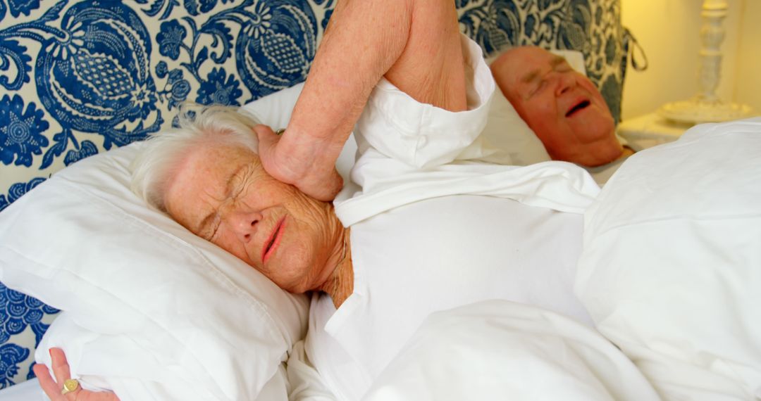 Elderly Woman Blocking Ears Due to Snoring Husband in Bed - Free Images, Stock Photos and Pictures on Pikwizard.com