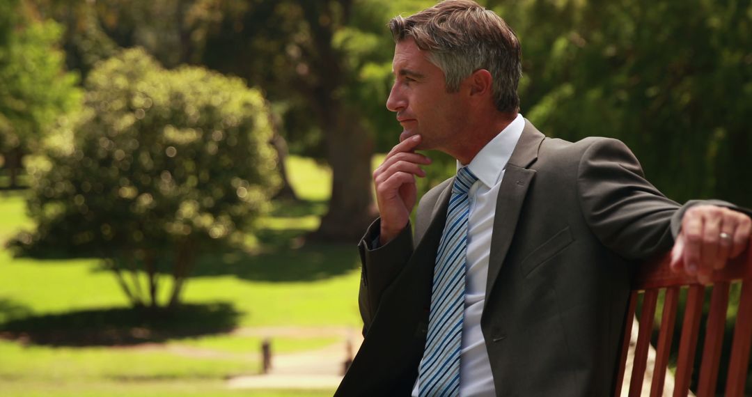 Pensive Businessman Sitting on Park Bench in Formal Suit - Free Images, Stock Photos and Pictures on Pikwizard.com