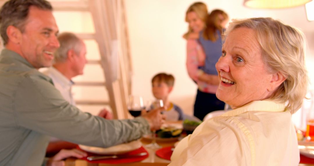 Elderly Woman Smiling During Family Gathering in Living Room - Free Images, Stock Photos and Pictures on Pikwizard.com