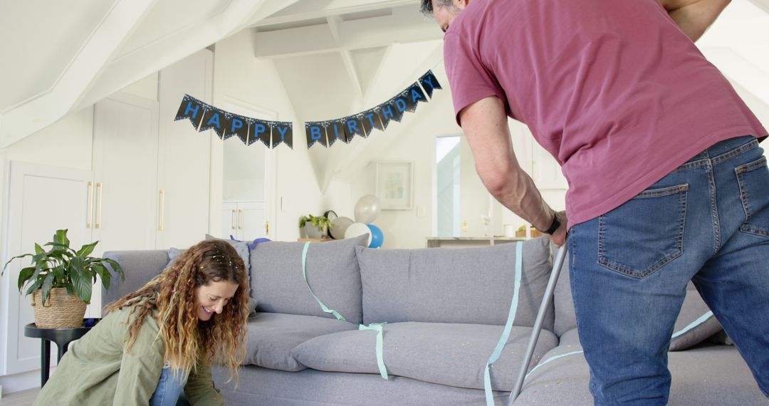 Couple Tidying Up After Birthday Party in Living Room