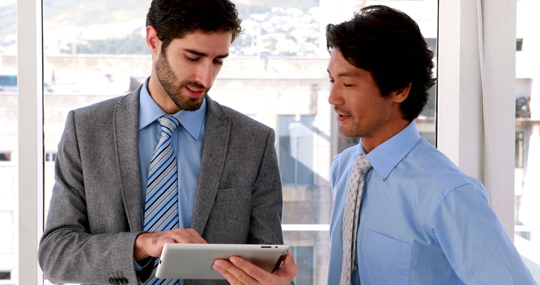 Professional Colleagues Discussing Work Strategies on Tablet