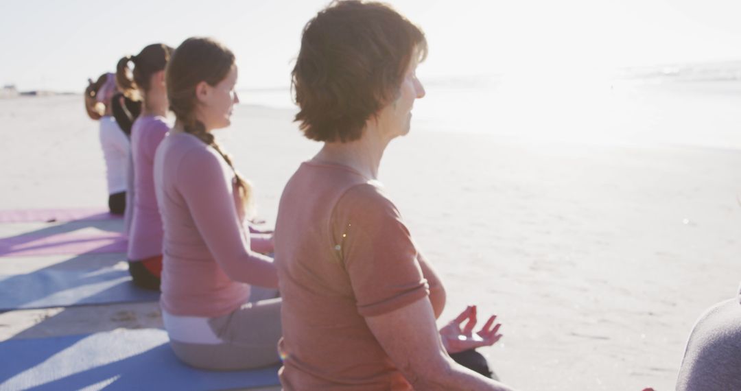 Group of Women Meditating on Beach During Sunny Day - Free Images, Stock Photos and Pictures on Pikwizard.com