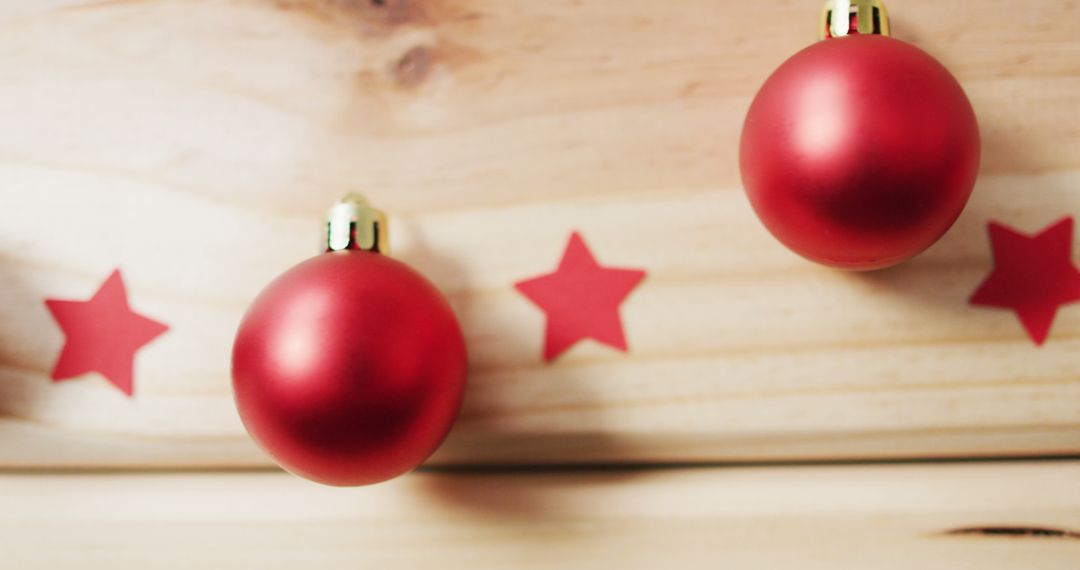 Image of red baubles and stars on pale wooden background - Free Images, Stock Photos and Pictures on Pikwizard.com
