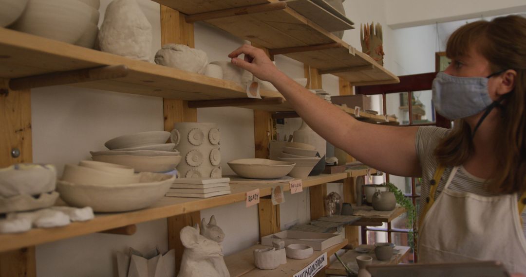 Female Potter Organizing New Ceramic Creations in Studio - Free Images, Stock Photos and Pictures on Pikwizard.com