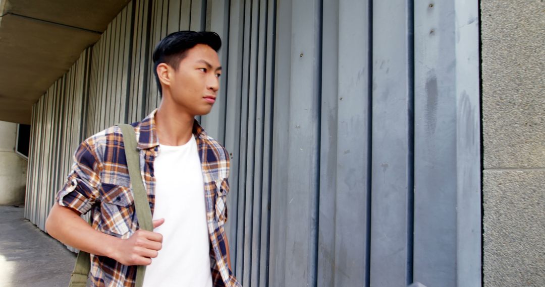 Young Man Leaning Against Metal Wall in Contemplative Pose
