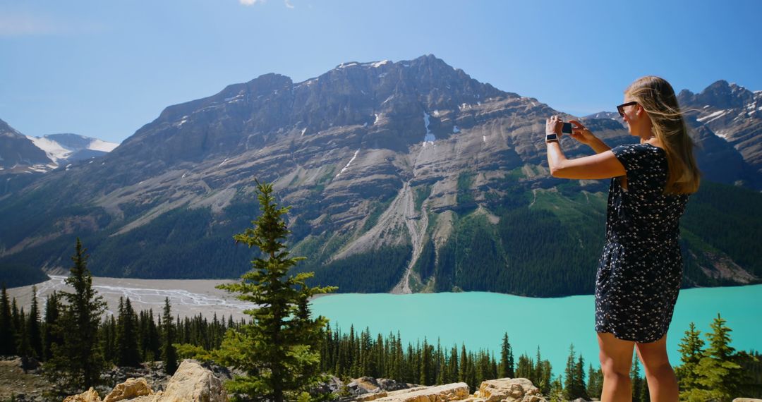 Woman Taking Photo of Mountain with Turquoise Lake - Free Images, Stock Photos and Pictures on Pikwizard.com