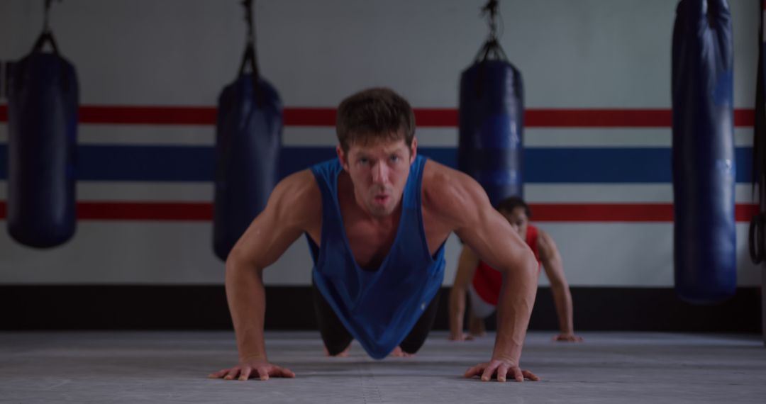 Focused Man Doing Push-Ups in Boxing Gym for Strength Training - Free Images, Stock Photos and Pictures on Pikwizard.com