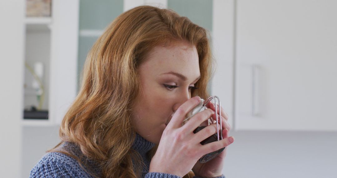 Young woman enjoying hot beverage in bright kitchen - Free Images, Stock Photos and Pictures on Pikwizard.com