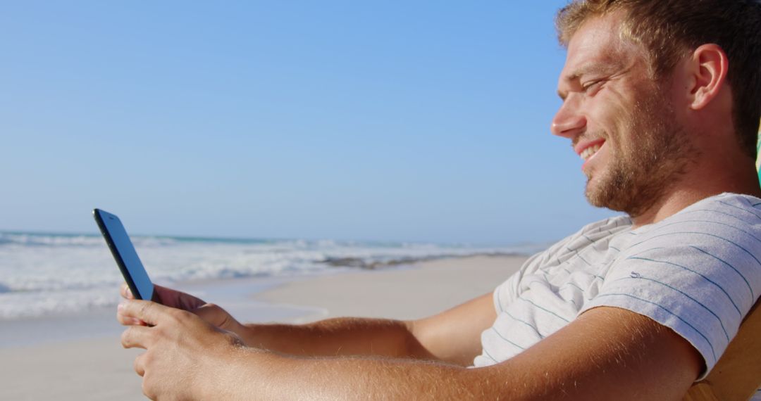 Smiling Man Enjoying Mobile Phone At Sunny Beach
