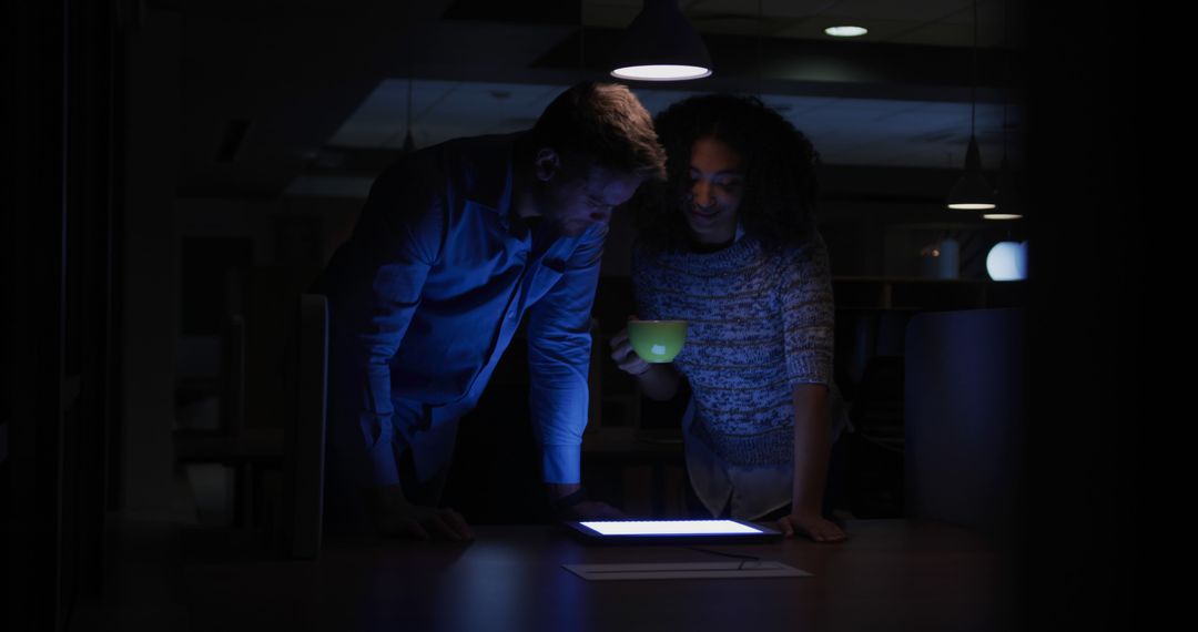 Two Colleagues Working Late Night Project in Dimly Lit Office - Free Images, Stock Photos and Pictures on Pikwizard.com