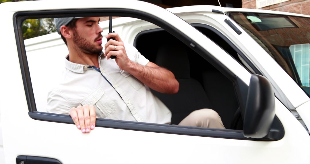 Male Delivery Driver Using Two-Way Radio in Truck - Free Images, Stock Photos and Pictures on Pikwizard.com