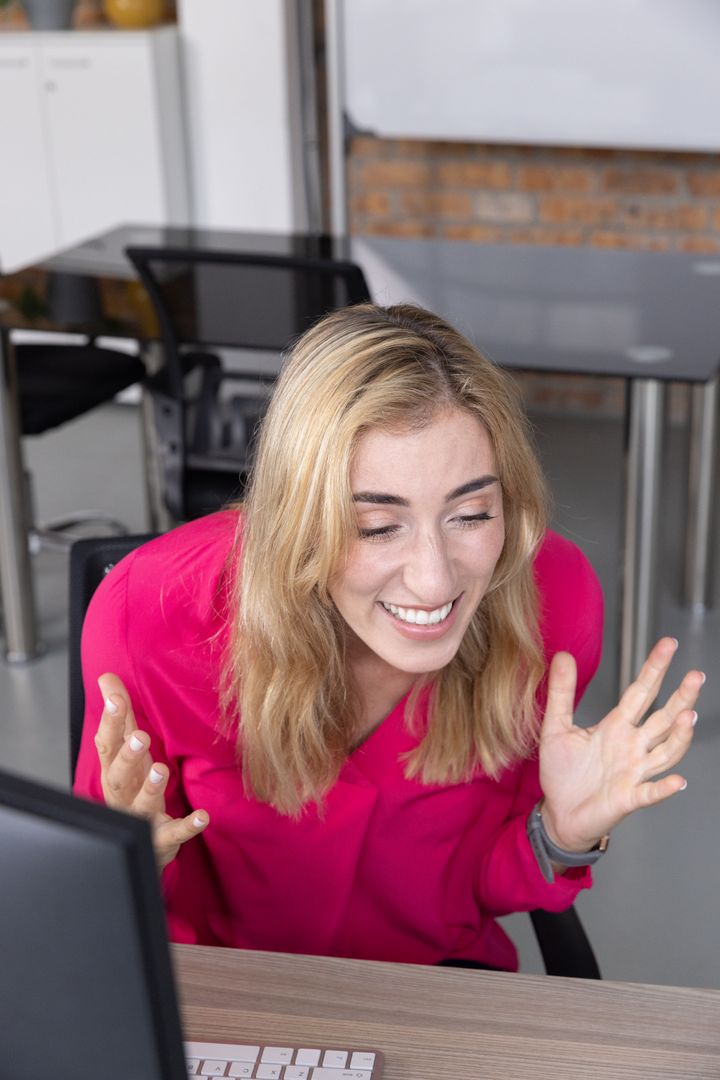 Enthusiastic Woman in Modern Office Raising Hands with Joy