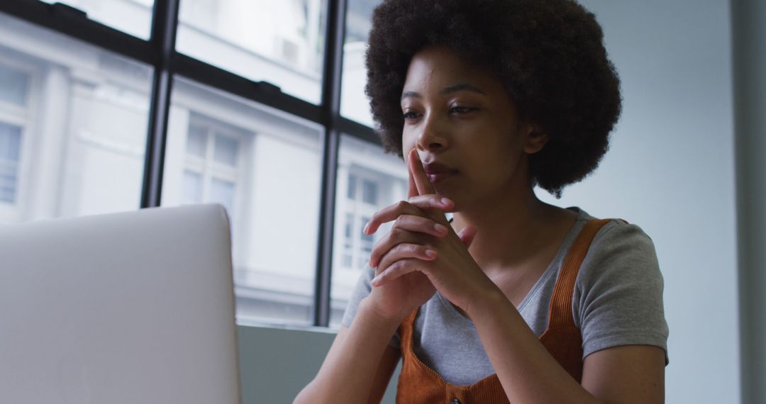 Focused Businesswoman Using Laptop in Modern Office Workspace