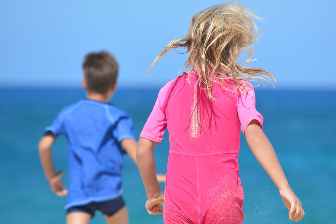 Children Running on Sunny Beach in Colorful Swimwear