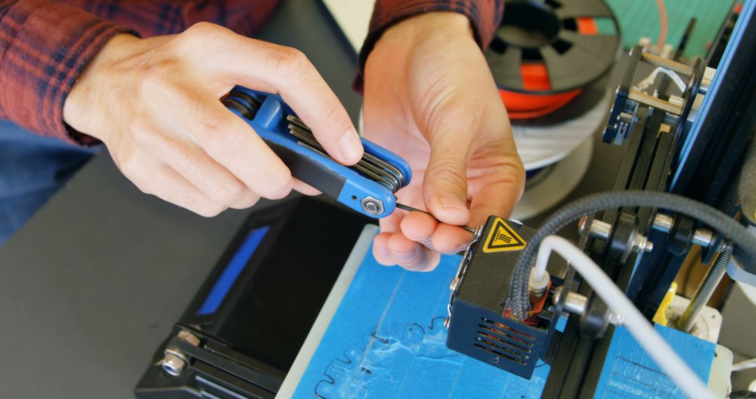 Hands Adjusting 3D Printer with Allen Wrench in Workshop - Free Images, Stock Photos and Pictures on Pikwizard.com