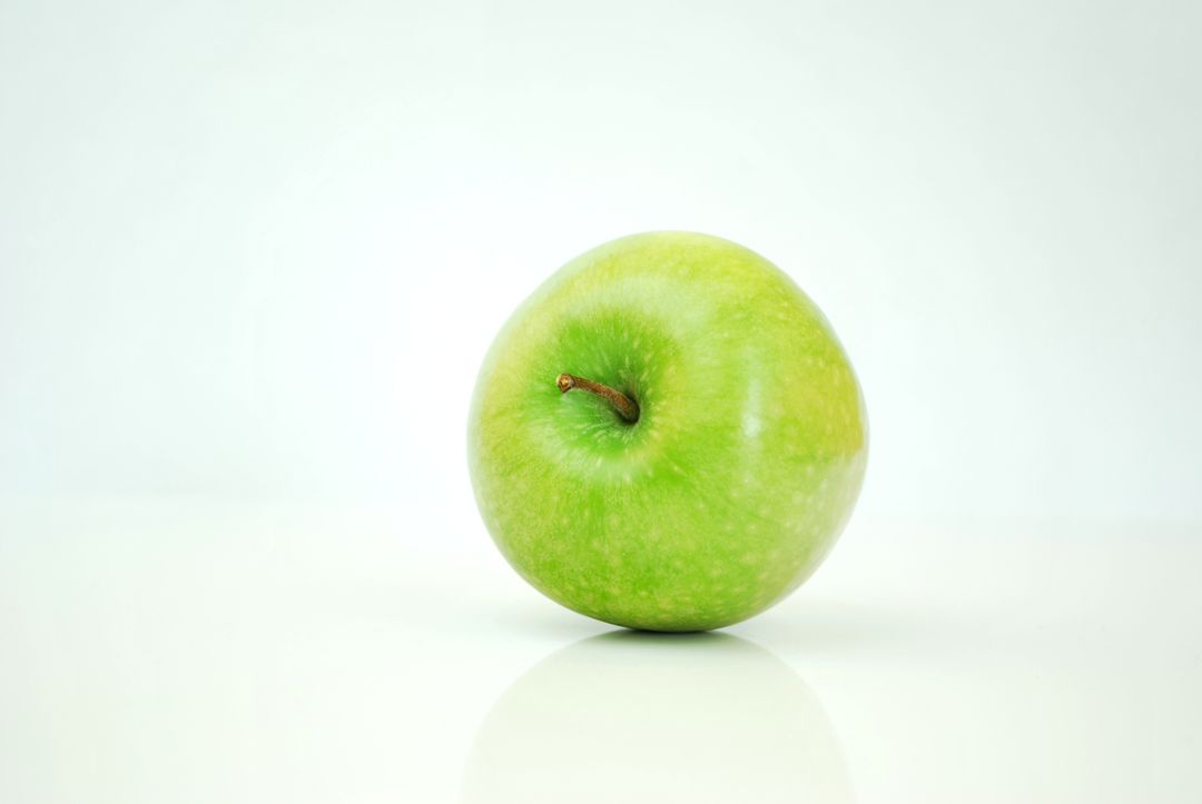 Fresh Green Apple on White Surface with Minimalist Background - Free Images, Stock Photos and Pictures on Pikwizard.com