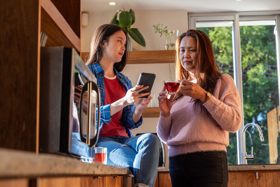 Mother and Daughter Enjoying Tea Time in Modern Kitchen