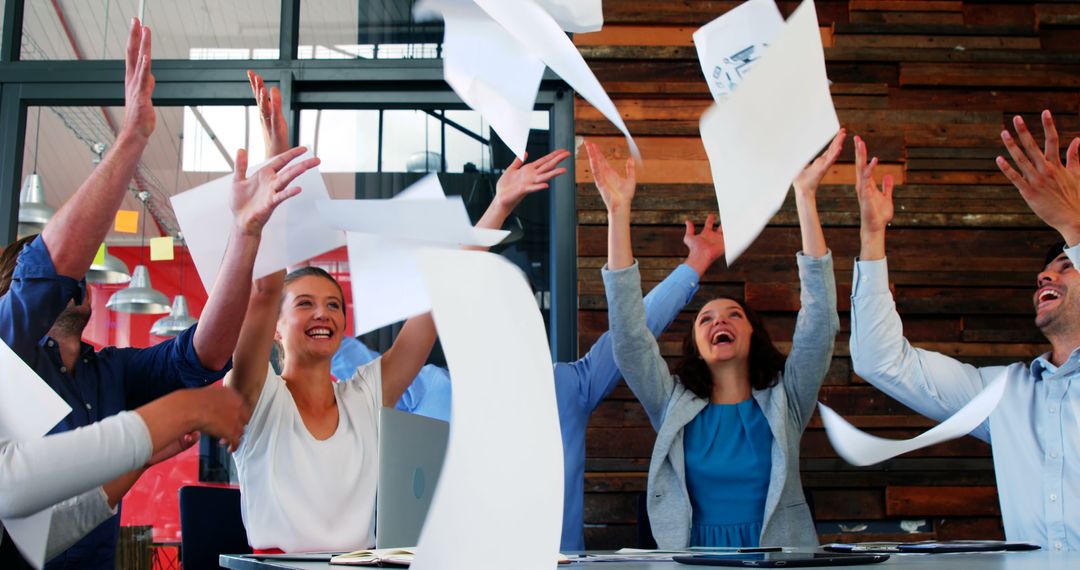 Business Team Celebrating Success by Tossing Papers in the Air - Free Images, Stock Photos and Pictures on Pikwizard.com