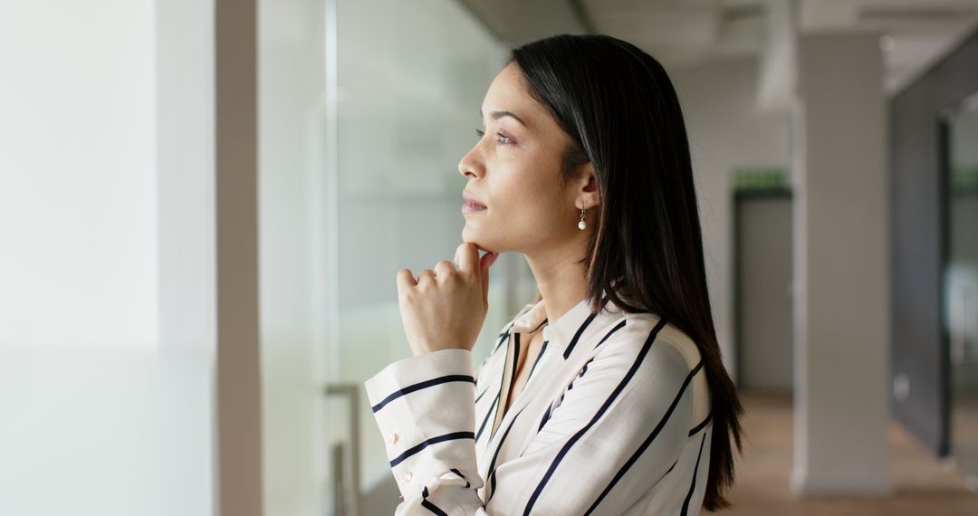 Businesswoman Deep in Thought Looking through Office Window