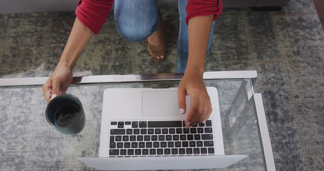 Person Working on Laptop While Holding Coffee - Free Images, Stock Photos and Pictures on Pikwizard.com