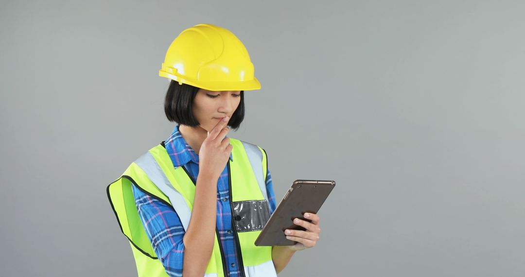 Female Construction Worker Inspecting Plans on Tablet - Free Images, Stock Photos and Pictures on Pikwizard.com