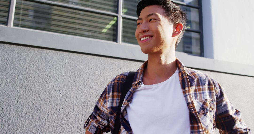 Smiling Young Man in Plaid Shirt Outdoors - Free Images, Stock Photos and Pictures on Pikwizard.com