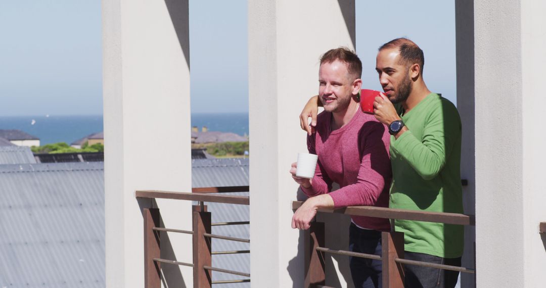 Interracial Gay Couple Enjoying Morning Coffee on Balcony - Free Images, Stock Photos and Pictures on Pikwizard.com