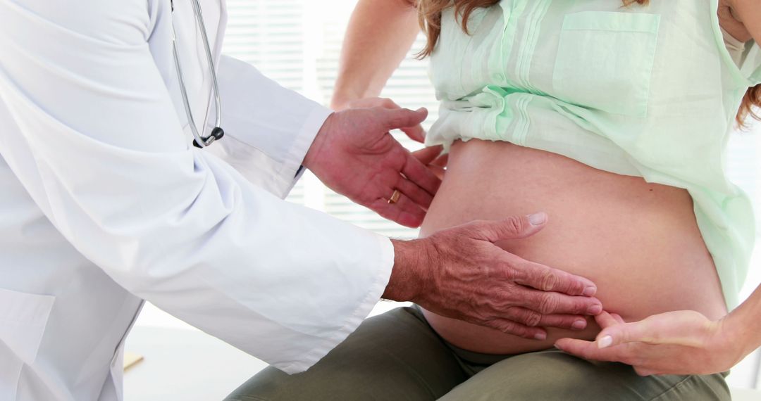 Doctor Examining Pregnant Woman's Belly in Medical Clinic - Free Images, Stock Photos and Pictures on Pikwizard.com