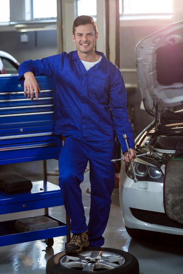 Portrait of mechanic with lug wrench - Free Images, Stock Photos and Pictures on Pikwizard.com