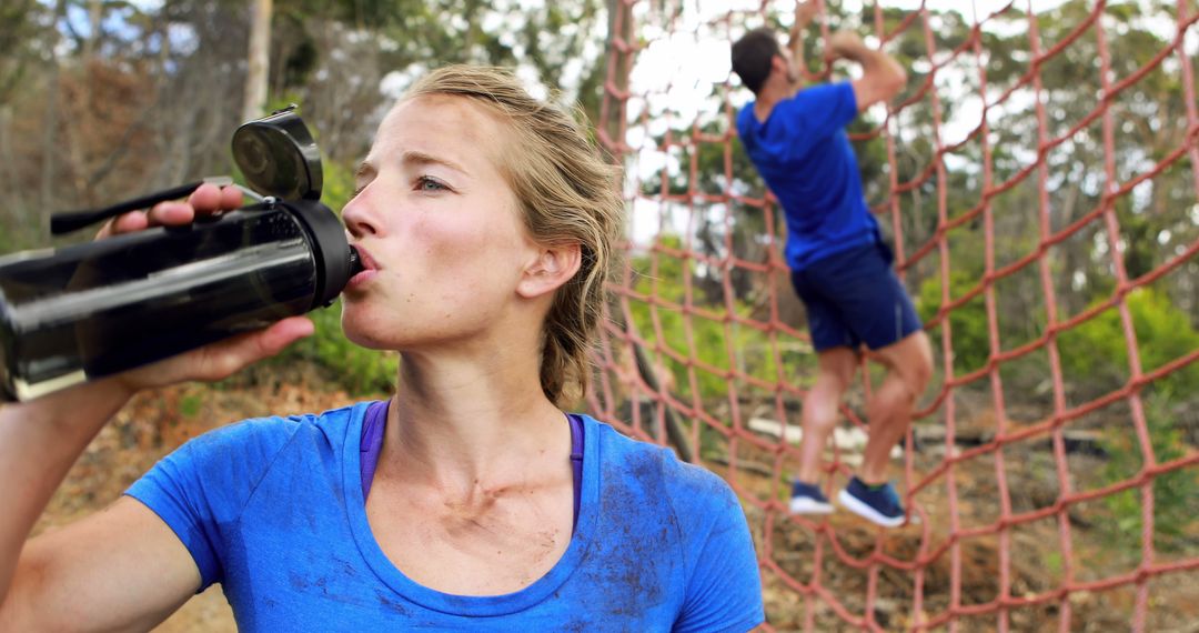 Woman Hydrating During Obstacle Course Training Outdoors - Free Images, Stock Photos and Pictures on Pikwizard.com