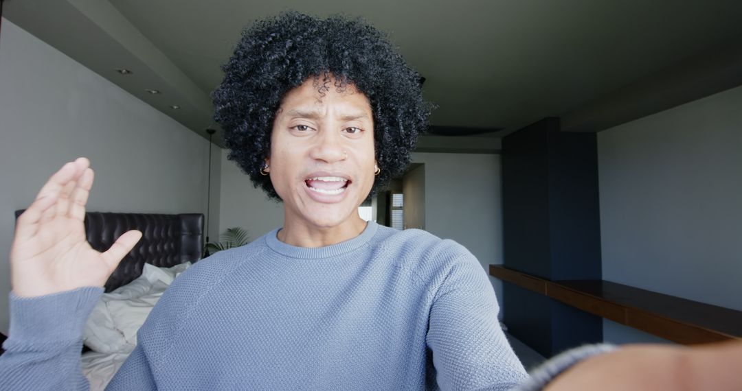 Man Expressively Communicating with Hand Gesture in Bedroom