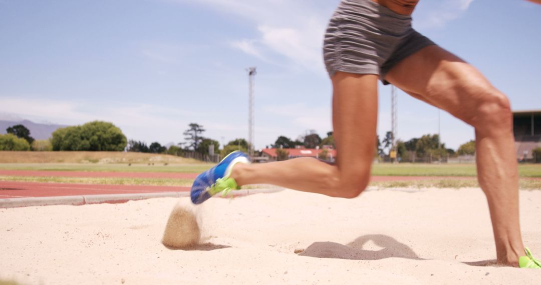 Athlete landing long jump in sand during track practice - Free Images, Stock Photos and Pictures on Pikwizard.com