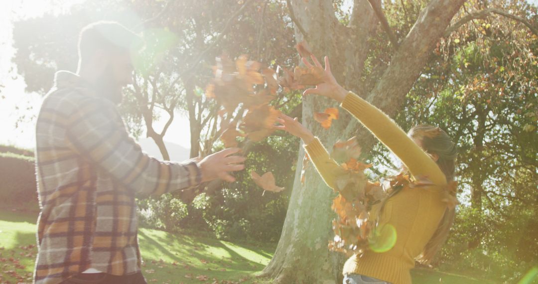 Couple Enjoying Playful Autumn Day Outdoors - Free Images, Stock Photos and Pictures on Pikwizard.com