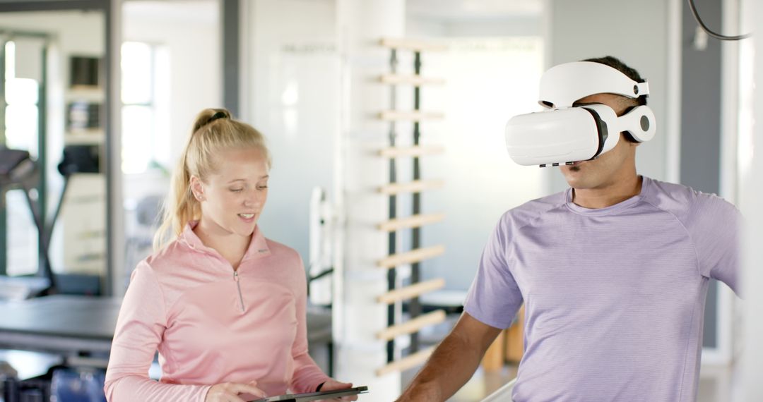 Man in Rehabilitation Using VR Headset Guided by Therapist with Tablet