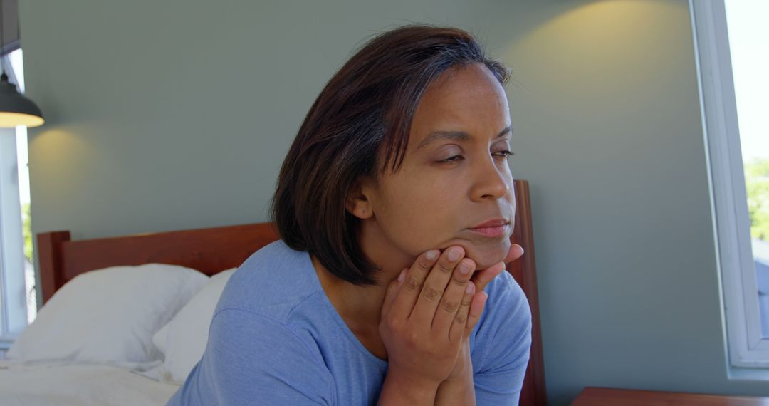 Woman Sitting on Bed Looking Thoughtful and Worried - Free Images, Stock Photos and Pictures on Pikwizard.com