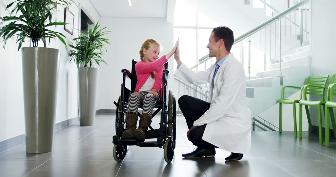 Doctor Giving High Five to Happy Girl in Wheelchair in Hospital Corridor - Free Images, Stock Photos and Pictures on Pikwizard.com