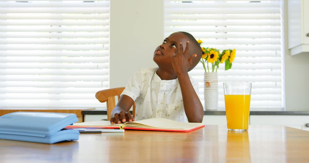 Young Boy Studying with Juice at Home Counting Fingers