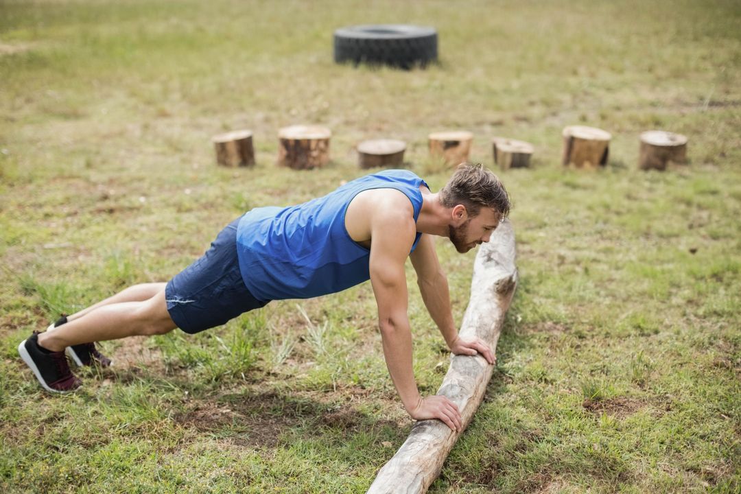 Athletic Man Performing Push-Ups Outdoors on Fallen Tree Trunk
