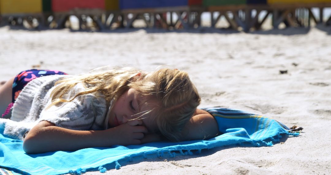 Young Girl Relaxing on Blue Towel at Sunny Beach - Free Images, Stock Photos and Pictures on Pikwizard.com