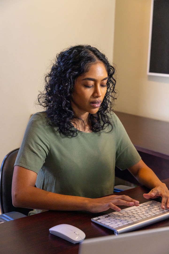 Focused Professional Woman Using Modern Keyboard at Office