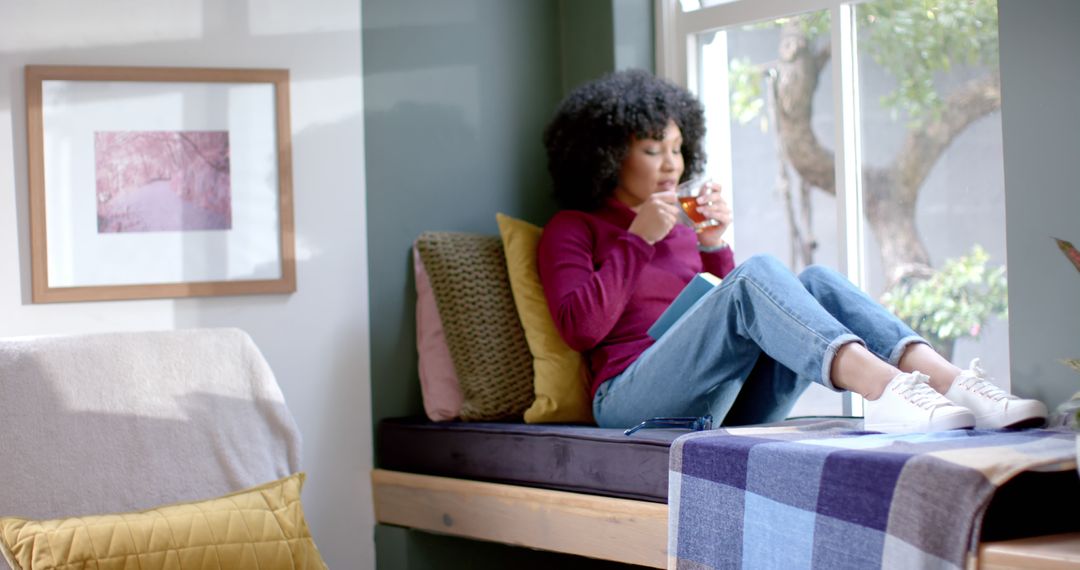 Woman Relaxing On Windowsill Drinking Tea In Cozy Home - Free Images, Stock Photos and Pictures on Pikwizard.com